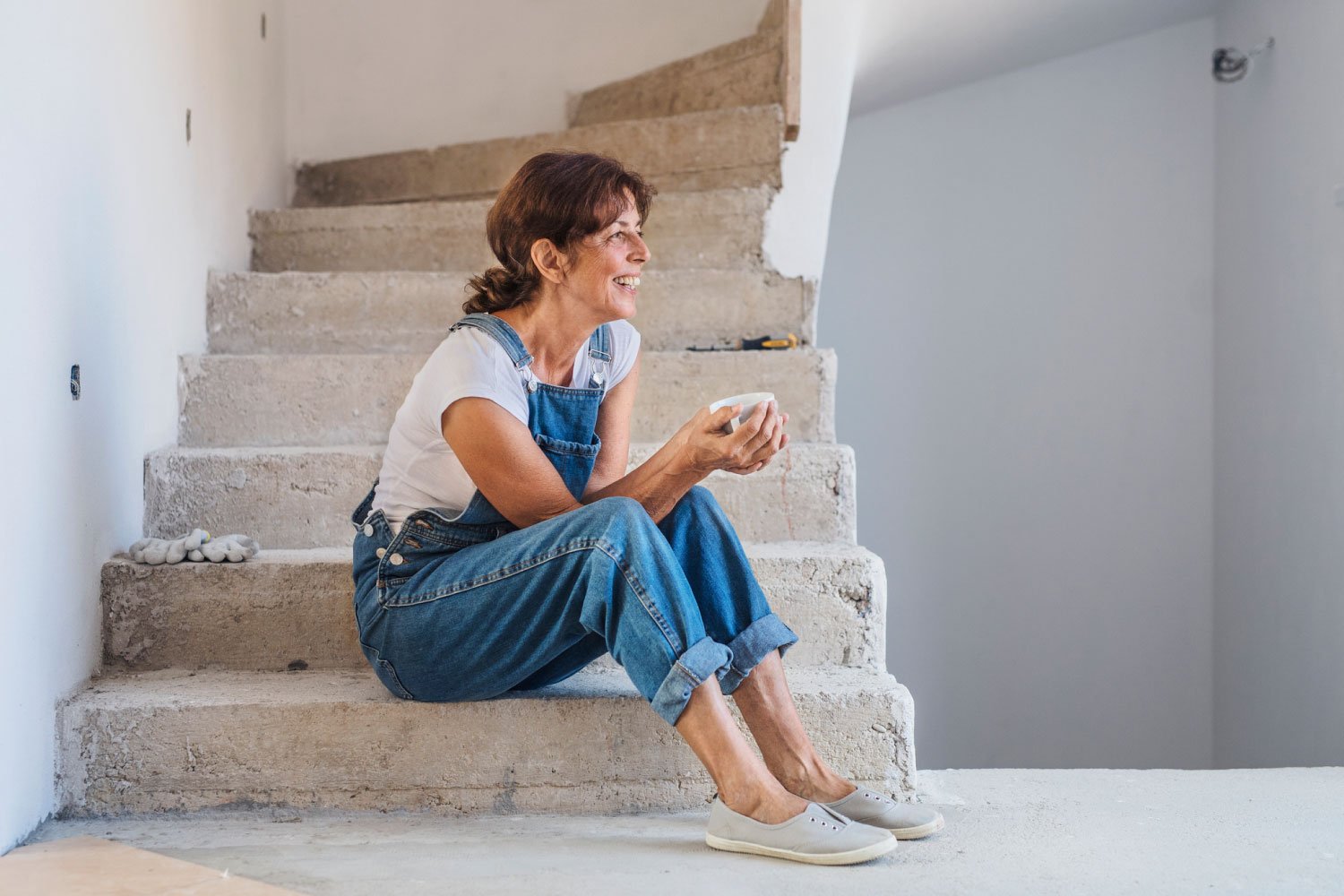 A woman sitting on the staircase of her stairs